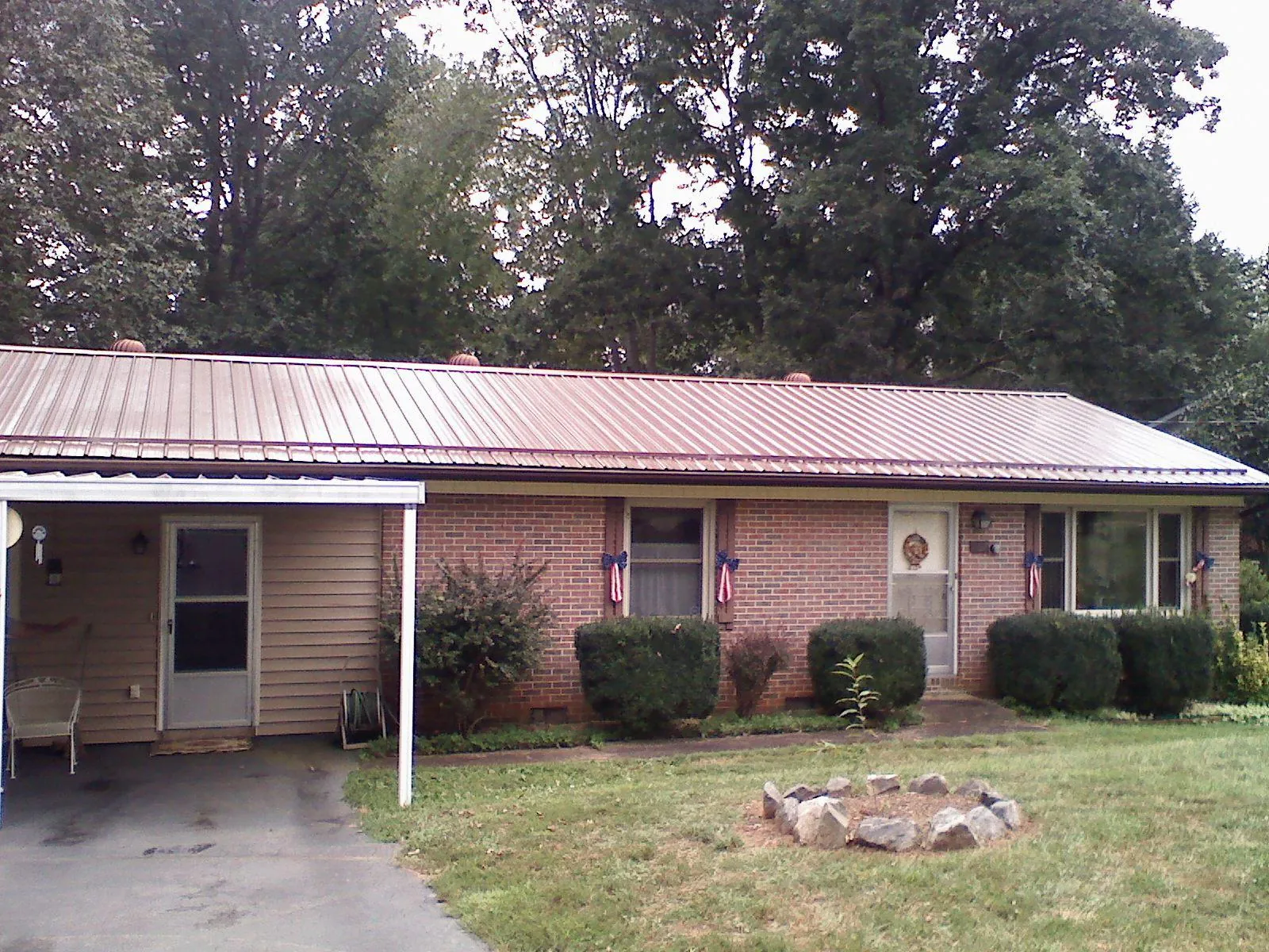 Bronze metal roof and carport on a brick ranch home — Roof Repair work by our crew in Griffin